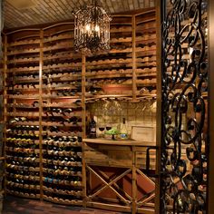 a wine cellar with lots of bottles and chandelier hanging from it's ceiling