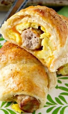 sausage egg and cheese breakfast roll ups on a green floral plate with a fork next to it