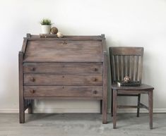 a wooden dresser sitting next to a chair with a potted plant on top of it