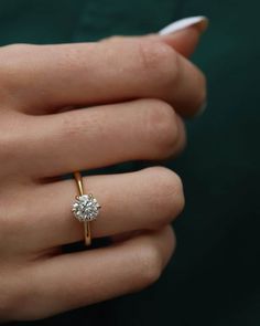 a woman's hand with a diamond ring on it