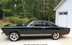 a black car parked in front of a garage