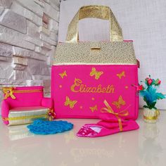 a pink lunch bag with butterflies on it next to other items and flowers in front of a brick wall