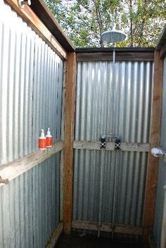 an outdoor shower with metal walls and toilet