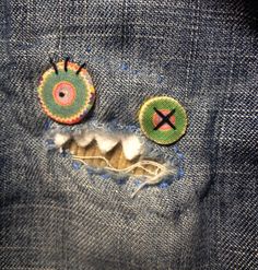 a pair of eyeballs in the back pocket of someone's blue jean jacket