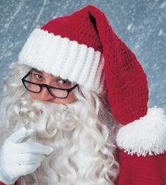 a man dressed as santa claus with long white curly hair and black rimmed glasses