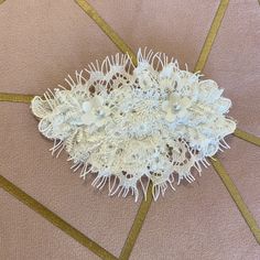 a white lace garter laying on top of a pink surface