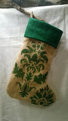 a green and white christmas stocking hanging from a tree