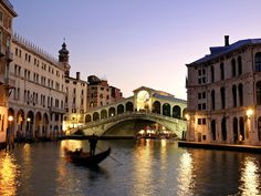 a gondola in the middle of a canal at dusk