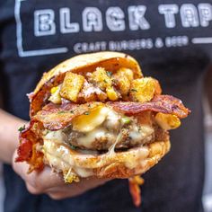 a close up of a person holding a sandwich with meat and cheese on it in their hand