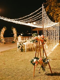 an outdoor wedding setup with flowers and lights