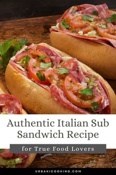 two italian sub sandwiches with tomatoes, lettuce and meat on them sitting on a cutting board