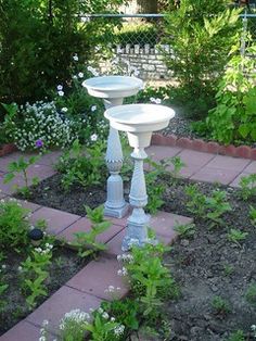 two white pedestals in the middle of a garden