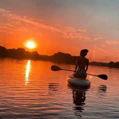 a person on a paddle board in the water at sunset