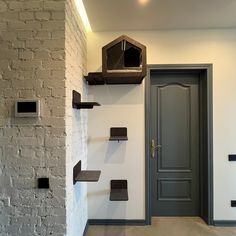 a white brick wall with shelves on it and a door in the middle, behind which is a clock