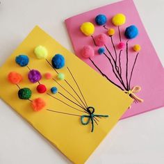 two cards with pom - poms on them, one is yellow and the other is pink