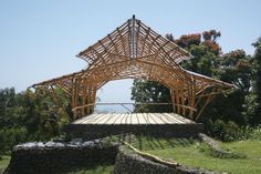 a wooden structure sitting on top of a lush green field