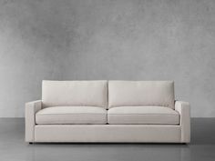 a white couch sitting in front of a gray wall