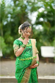 a woman in a green sari holding her hand to her mouth