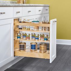 an open spice rack in a kitchen with white cabinets and wood flooring on the side