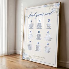 a wedding seating chart is displayed in front of a window with white curtains and wood flooring