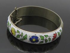 "SIAM 925 Sterling Silver - Vintage Enamel Floral Detail Bangle Bracelet - BT6885  SIAM 925 Sterling Silver - Vintage Enamel Floral Detail Bangle Bracelet - BT6885  Jewelry Type:         Bracelet  Metal Type:            925 Silver   Metal Size:             7.5\" Length  .50\" Height   Stone Type:            N/A  Condition:              N/A  Jewelry Weight:     26.8 Grams   PLEASE NOTE: THIS ITEM IS PRE-OWNED. ALTHOUGH MOST ITEMS ARE IN VERY GOOD CONDITION, SOME MAY NEED CLEANING AND/OR MINOR REPAIRS. WE MAKE A VERY STRONG EFFORT TO UPLOAD CLEAR PICTURES. PLEASE INSPECT ALL PICTURES AND ASK ALL QUESTIONS YOU MAY HAVE PRIOR TO MAKING A PURCHASE. NOT ALL STONES ARE GENUINE, SOME ARE ENHANCED OR CREATED." Collectible White Bracelet Jewelry, Bracelet Metal, Beautiful One, Metal Bracelets, Bangle Bracelet, Types Of Metal, Etsy Gifts, Sell On Etsy, Metallic Silver