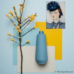 a blue vase sitting on top of a table next to a painting and a plant