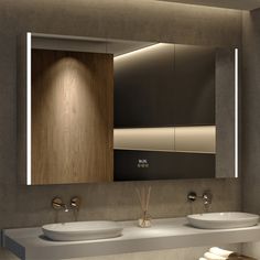 a bathroom with two sinks and a large mirror above the sink is illuminated by lights