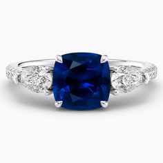 a blue sapphire and diamond ring with two diamonds on the sides, set in white gold