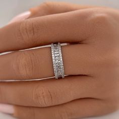 a woman's hand with a diamond ring on her left hand and the other hand holding