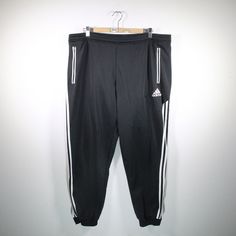 Cool vintage training pants in size XL from Adidas. Basic color black. Waist width is approx. 45 cm and stretchy and length approx. 111 cm. Has a tying waistband at the hips and practical pockets. Without inner lining. Has zippers at the ends of the pants. 100% polyester. You can find more sports pants and other vintage clothes in our Etsy shop. If you have any questions, just write to us! Your soul & style from Berlin P.S.: Our clothes are vintage, so not new. We list defects that go beyond exp Black Joggers With Elastic Side Panels For Jogging, Black Sweatpants With Elastic Side Panels For Sports, Black Joggers With Elastic Side Panels, Black Sportswear Joggers With Elastic Side Panels, Black Joggers With Elastic Side Panels For Sportswear, Black Sweatpants With Three Stripes, Black Joggers With Elastic Waistband For Jogging, Black Sweatpants With Elastic Panels For Jogging, Sporty Black Sweatpants With Elastic Waistband