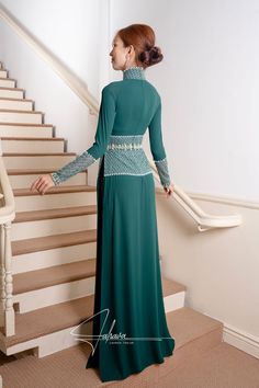 This exquisite ao dai is expertly designed with a traditional collar and floor-length silhouette, showcasing its rich moss green hue. Crafted from luxurious fabric, it also comes with a pair of black pants, making it perfect for any formal occasion. Let this timeless piece elevate your wardrobe with its elegant and sophisticated appeal. Elegant Fitted Dark Green Gown, Elegant Dark Green Long Sleeve Maxi Dress, Traditional Green Evening Gown, Formal Fitted Floor-length Ao Dai, Formal Floor-length Fitted Ao Dai, Elegant Fitted Long Ao Dai, Elegant Floor-length Fitted Ao Dai, Traditional Full-length Green Dress, Traditional Full Length Green Dress