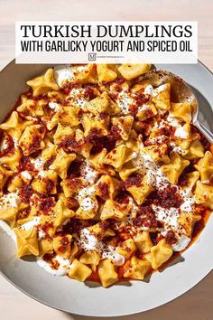 a bowl filled with pasta and sauce on top of a wooden table