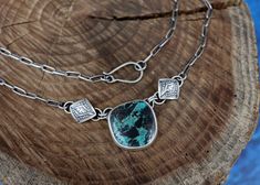 This necklace features a stunning and rare piece of Blue Diamond Turquoise that’s full of a deep teal and bold, painterly black markings - it definitely packs a punch! The stone is adorned with one of my favorite elements, hand stamped puffy diamonds. The silver is oxidized to bring out all the fine details and depth and is topped off with a brushed finish. The pendant hangs on a 17’’ sterling silver paperclip chain with a handmade clasp. The chain has been darkened to match the patina on the pe Turquoise Chrysocolla Necklace With Patina, Artisan Necklace With Large Chrysocolla Pendant, Handmade Pendant Necklace, Deep Teal, Handmade Pendant, Blue Diamond, Handmade Pendants, Paper Clip, Hand Stamped