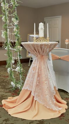 a table with a cake on top of it in front of a chair at a wedding