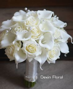 a bridal bouquet with white roses and pearls