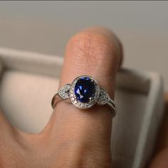 Silver Lab-created Sapphire Ring With Halo Design, Oval Sapphire Promise Ring In 14k White Gold, Oval Sapphire Promise Ring, Sapphire Ring With Halo Design For Gift, Ethical Sapphire Oval Ring For Promise, Classic Silver Sapphire Ring With Lab-created Sapphire, Classic Oval Sapphire Birthstone Ring, Classic Silver Sapphire Ring, Oval Sapphire Ring In Sterling Silver