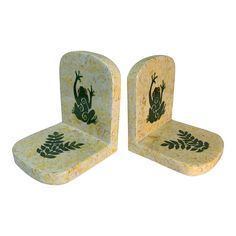 two stone chairs with green designs on them