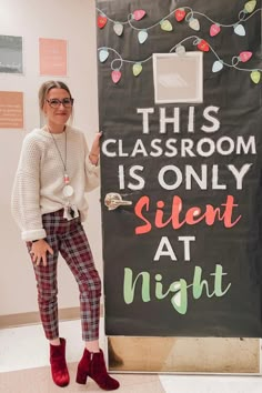 a woman standing next to a sign that says this classroom is only silent at night