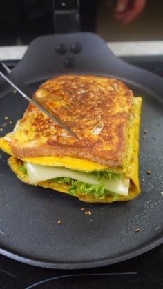 a grilled sandwich sitting on top of a black plate