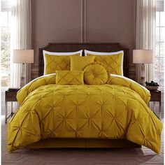 a bed with yellow comforters and pillows