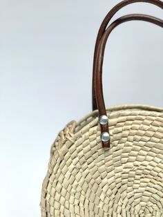 Sustainably Handwoven Straw Circle Bag The Mia Straw Circle Bag is lightweight and durable. This small-size bag will hold all of your essential items. It's the perfect bag for cruising around town. These bags are individually hand-woven with sustainable palm leaves and have naturally tanned leather handles. Thoughtfully designed and ethically made by artisans in Guerrero, Mexico, in a fair trade environment. Each bag is unique and may vary in size, and color, and may have small imperfections. De Summer Woven Leather Bag With Round Handle, Beige Straw Bag With Woven Leather And Round Handle, Summer Straw Bag With Woven Leather And Round Handle, Vacation Shoulder Bag With Woven Leather And Round Handle, Everyday Woven Leather Beach Bag With Double Handle, Everyday Double Handle Woven Leather Beach Bag, Natural Color Basket Shaped Woven Leather Bag, Natural Basket Shaped Woven Leather Bags, Natural Woven Leather Basket Bag