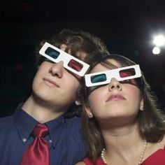 two people wearing 3d glasses in the dark