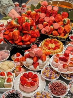 a table topped with lots of different types of desserts and pastries next to each other