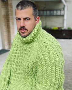 a man wearing a green knitted sweater