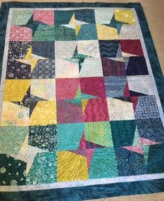 a multicolored patchwork quilt on the floor