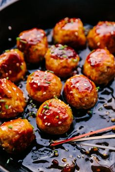 meatballs with sauce and chopsticks in a skillet