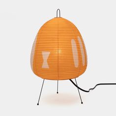 an orange lamp with white letters on it and a black cord attached to the base