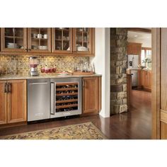 a kitchen with wooden cabinets and stainless steel appliance on the counter, along with an area rug