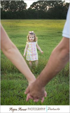 two people holding hands in the grass