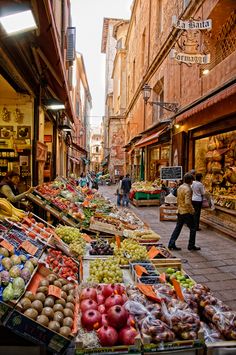 an outdoor market with lots of fresh fruits and vegetables on the side of the street